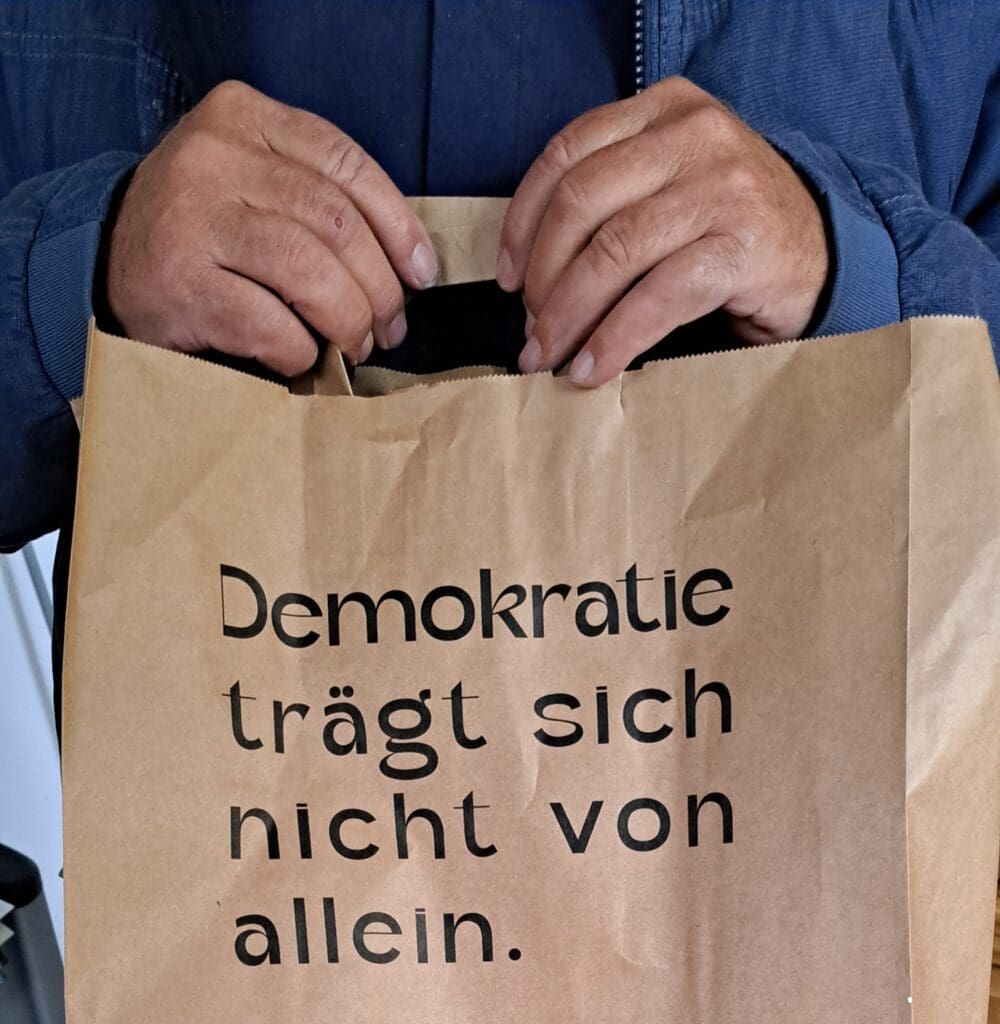Papiertasche mit der Aufschrift "demokratie trägt sich nicht von allein."